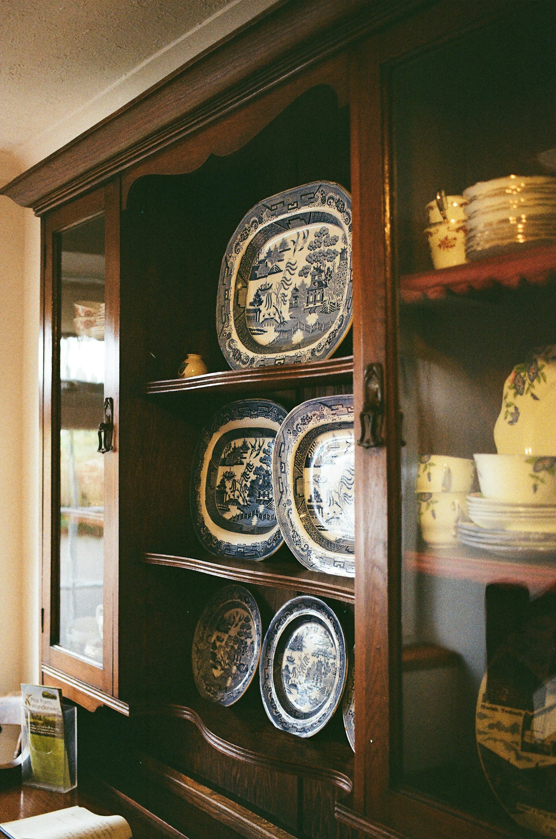 An aged wooden cabinet holding carefully arranged ceramics